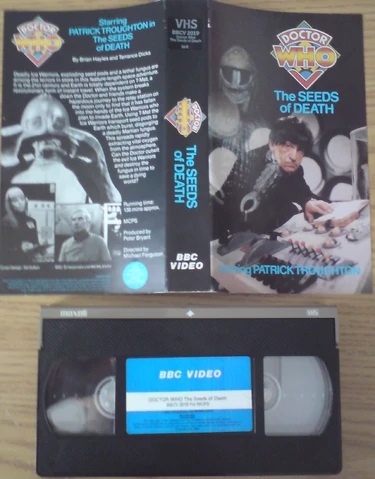 1985 UK PAL VHS Release sleeve and video tape (no "U" certificate on sleeve or tape label). Note the writer's credit "By Brian Hayles and Terrance Dicks" on the rear sleeve, as well as the blue sticker — which reads THE ORIGINAL BLACK AND WHITE RECORDING — in the bottom right-hand corner.