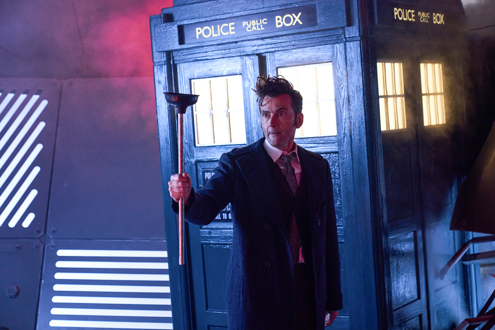 The Doctor wields a plunger.