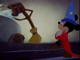 Mickey watches as the broom dumps water from a bucket.