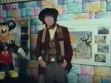 The Fourth Doctor stands near a Mickey Mouse statue.