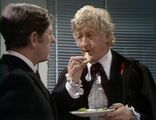 The Doctor eats sandwiches holding plate.jpg