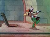 Goofy sings as he walks over to a bell.