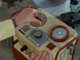 At the Doctor's prompting, Liz adjusts the dials.