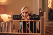 Ruby leans on a wooden cot.