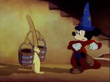 Mickey shows the broom how to walk.