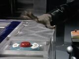 Davros's hand seizes up as he is exterminated, unable to reach the button to switch off the automated production line.