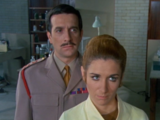 Liz and the Brigadier watch as smoke streams out of the police box.