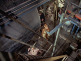 The Doctor, the Brigadier and Liz seen from above as they enter the Auto Plastics factory.