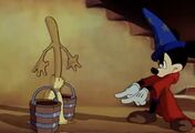 Mickey tells the broom to pick up 2 wooden buckets from the floor.