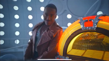 The Fifteenth Doctor stands next to his jukebox.