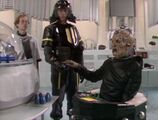 Davros hands capsules containing samples of the Movellan virus to a Dalek Trooper.