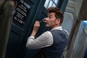 The Doctor pries at the TARDIS's keyhole with a not-sonic screwdriver.