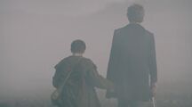 The Doctor and Davros walk off into the mist, hand in hand.