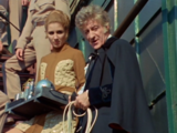 Liz continues to hold the bulk of the Auton-disabling device as the Doctor prepares to use it on the fake Scobie.